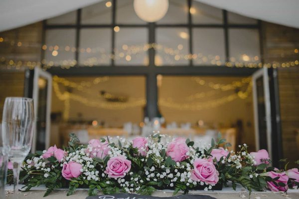 A photograph of beautiful blush pink roses at a barn wedding