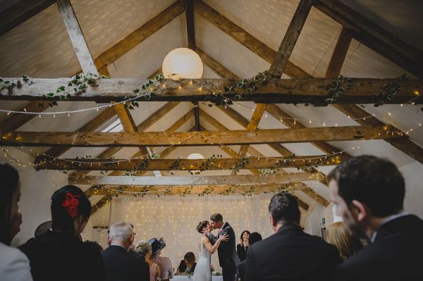 Newly weds kissing after the ceremony in a wedding barn at a A Countryside wedding venue