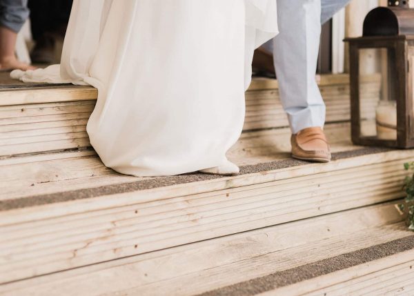 Newly wed couple walking down wooden steps to the beach