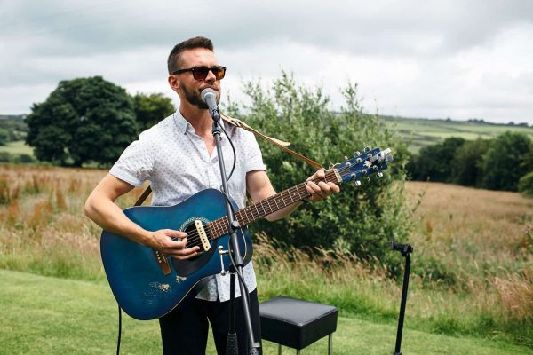 A photograph of a singer with guitar wedding entertainment live gentle vocals