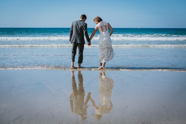 A photograph of a bride and groom on beach, Lusty Glaze Beach Weddings
