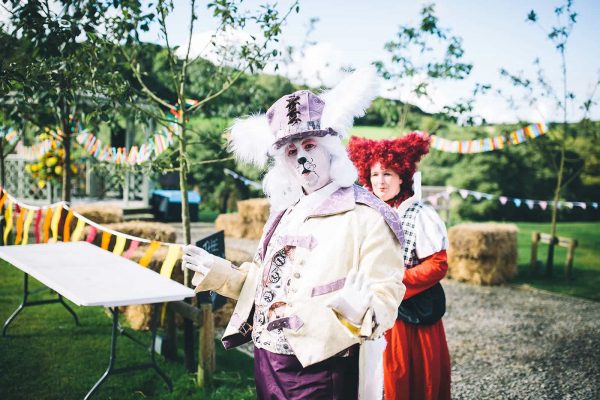 A photograph of The White Rabbit and the Queen of Hearts at a Mad Hatters Tea Party Wedding Reception