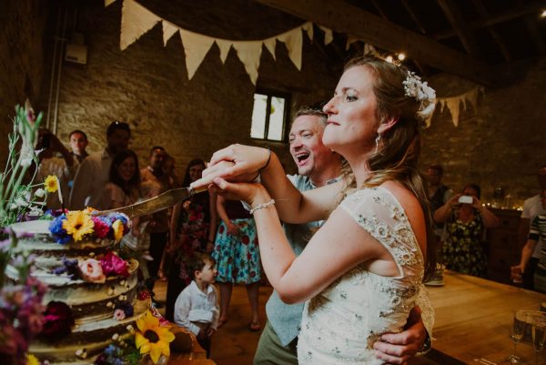 A photograph of newly weds cutting the cake. Beautiful emotional moments captured