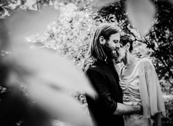 Newly engaged couple cuddling in a garden by Verity Westcott Wedding Photographer