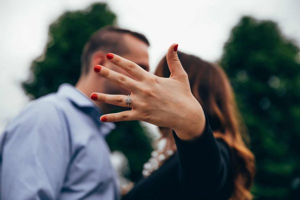 engaged couple with the lady holding out her hand and displaying the ring