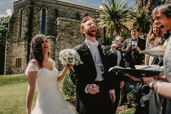 Newly weds laughing outside of church captured by Andrew George Wedding Photography