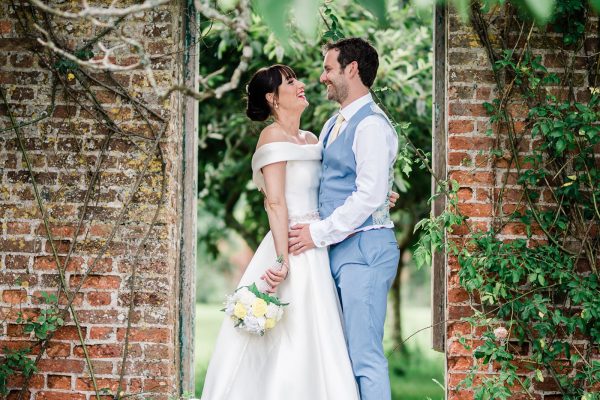 newly weds standing in a garden by Take One Photos & Film